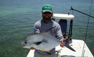 Flats fishing captain with a Permit fish