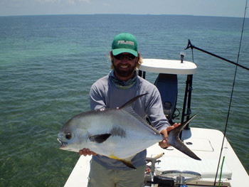 Flats fishing captain with a Permit fish