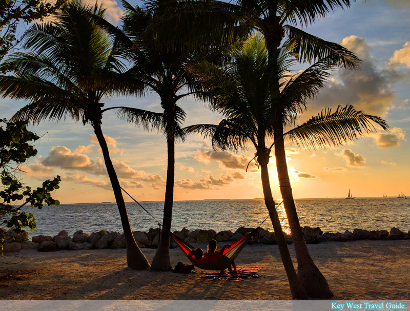 Two visitors to Fort Zachary Taylor State Park enjoy the sunset while swinging in a hammock