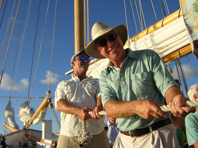 Raising the main sail aboard a traditional sailing schooner.