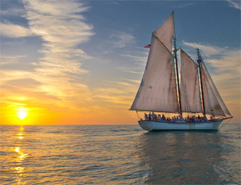 Tall ship schooner with full sails up just before sunset in Key West